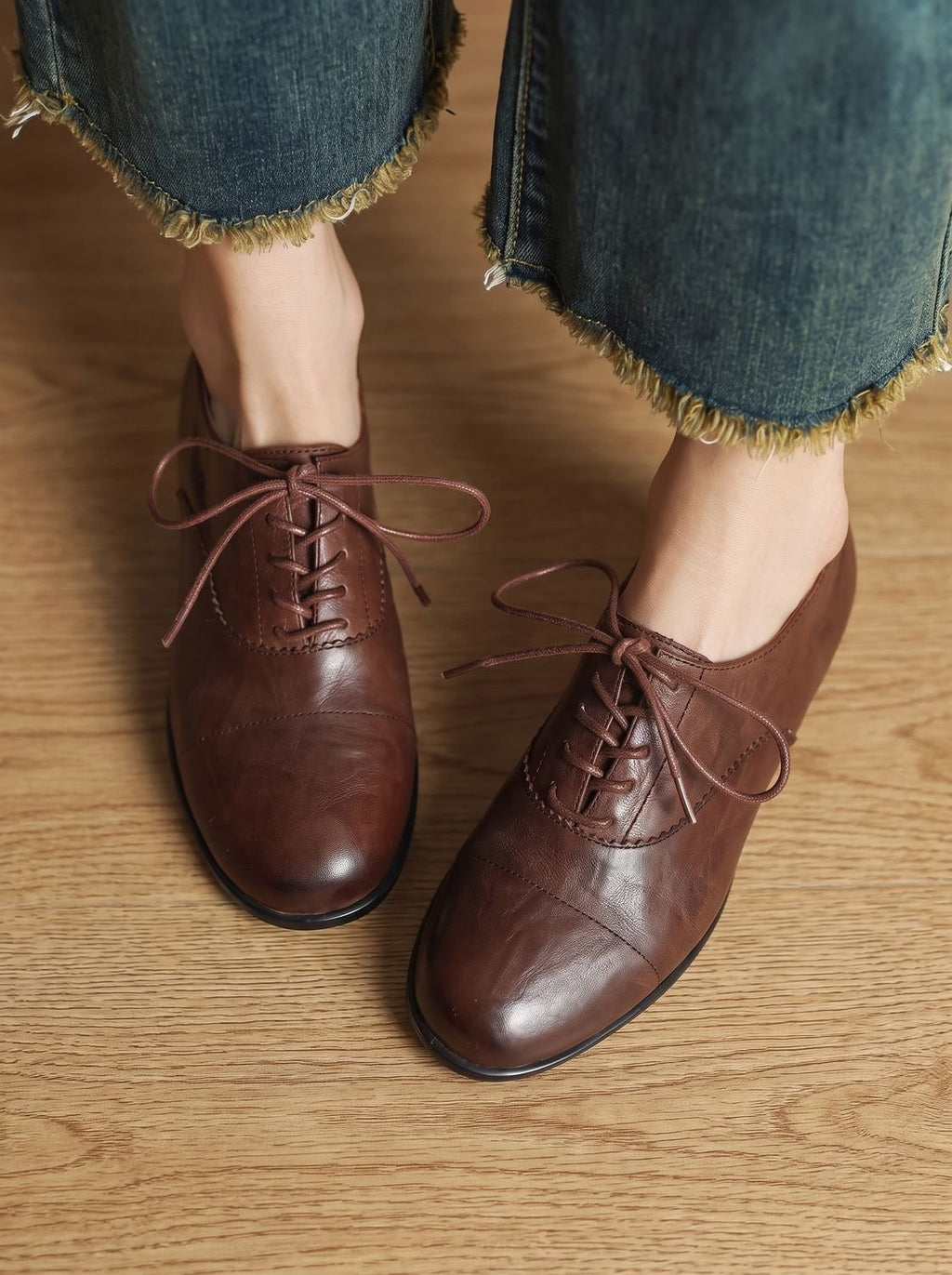 Zapatos oxford de mujer en tono caramelo sobre fondo neutro