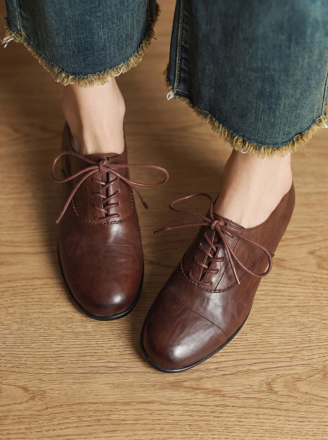 Zapatos oxford de mujer en tono caramelo sobre fondo neutro