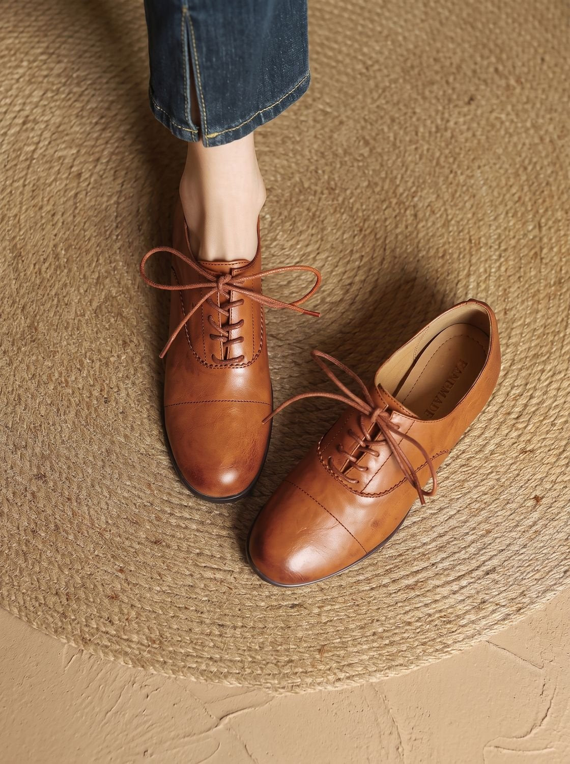Vista lateral de los zapatos oxford planos de piel color caramelo