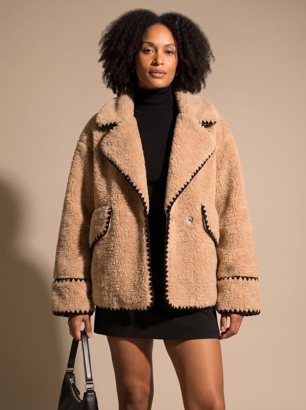 Detalle de la solapa y el ribete negro del abrigo teddy fleece