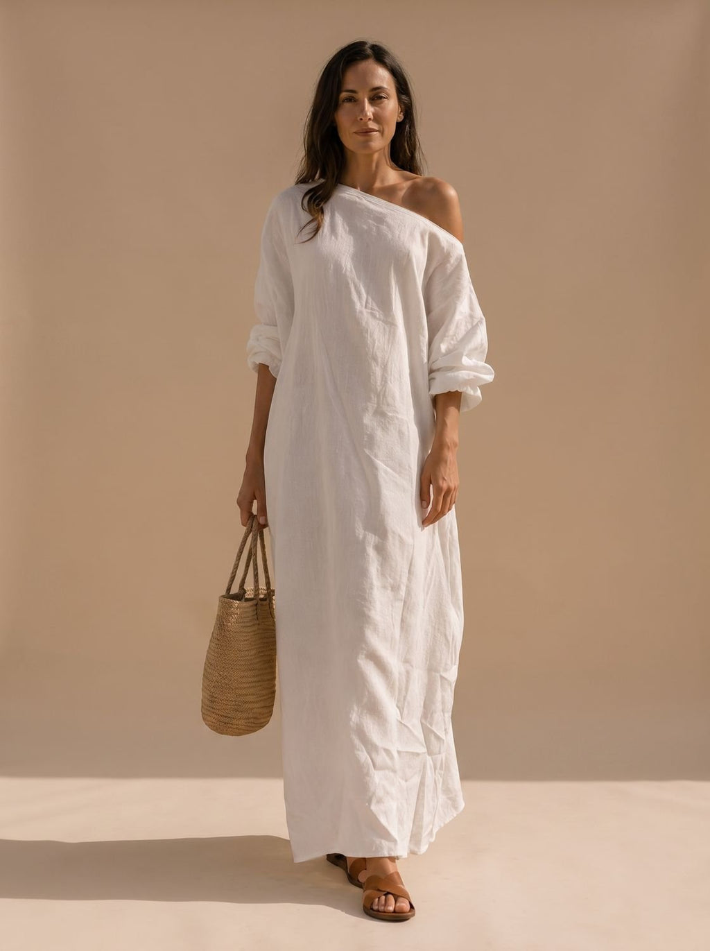 Mujer con vestido maxi boho de un hombro y manga ancha en tono neutro