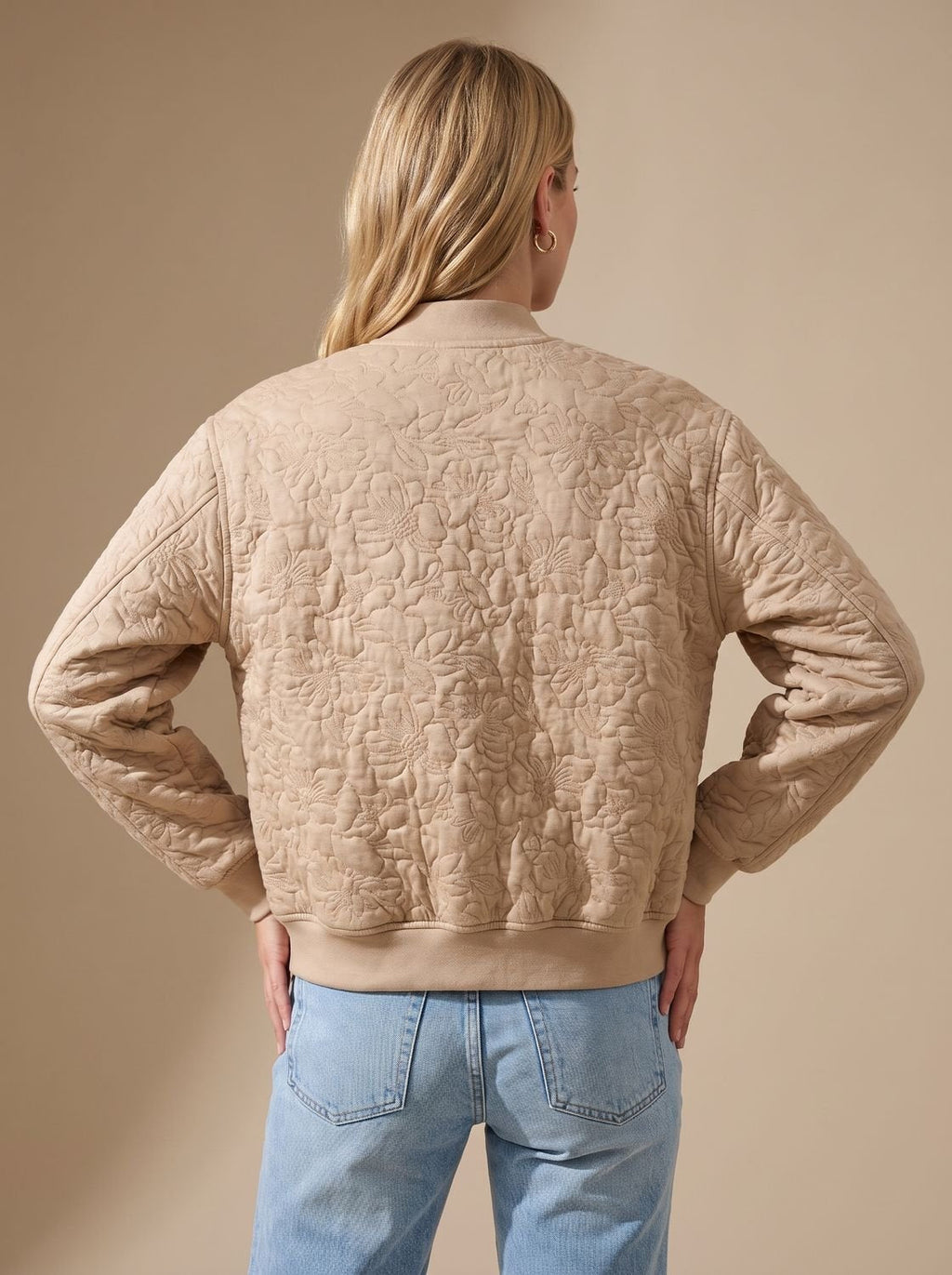 Detalle del acolchado floral en relieve de la cazadora bomber beige