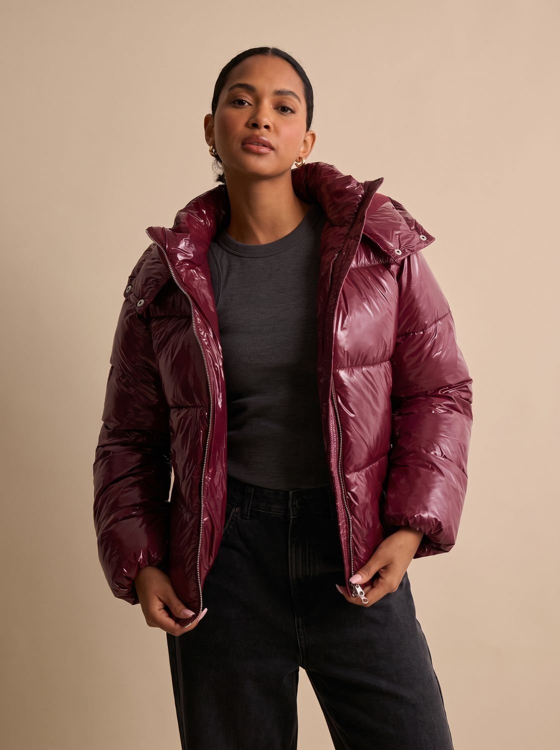 Mujer con plumífero acolchado brillante y capucha, ideal para looks de otoño e invierno