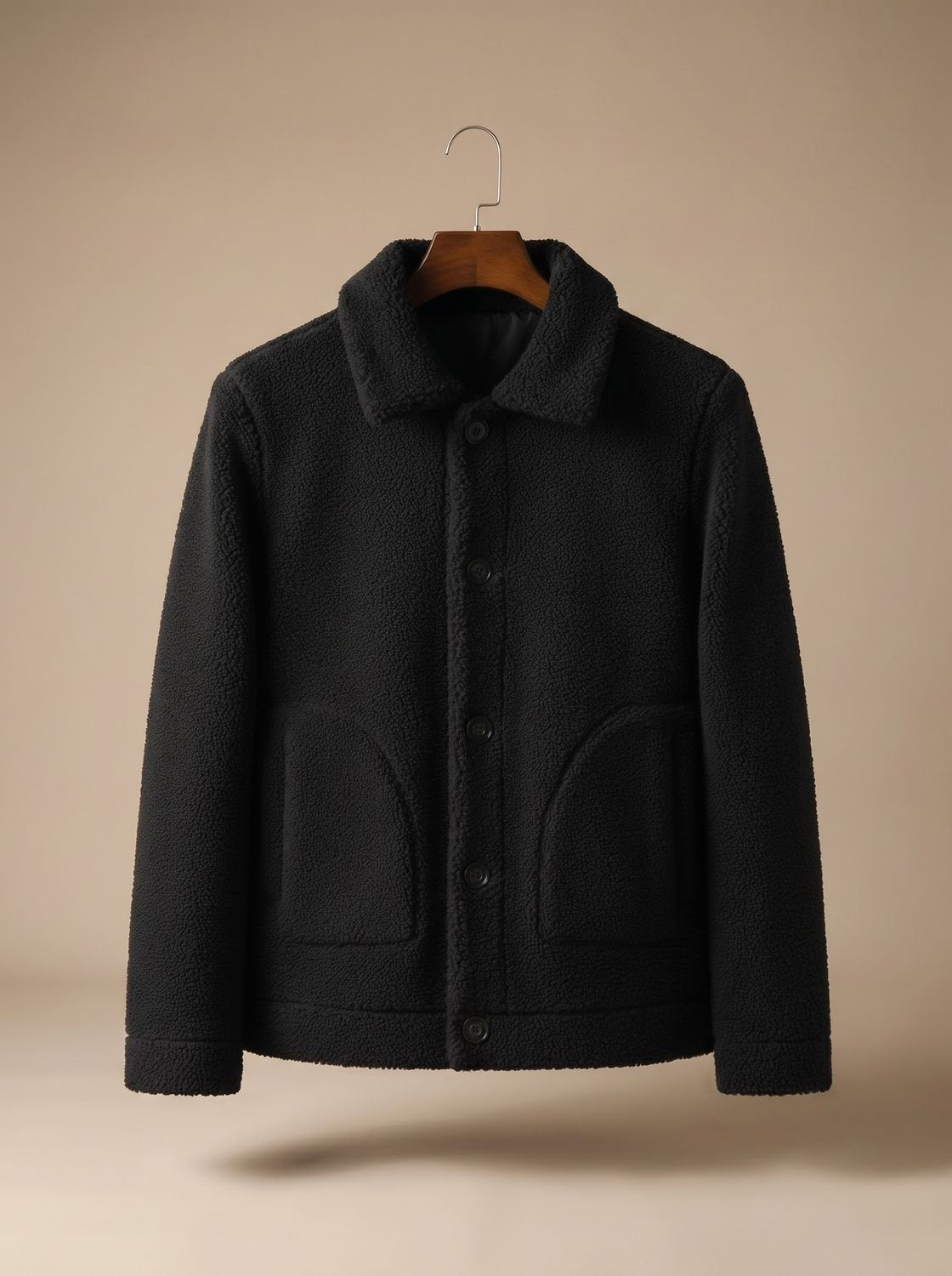 Detalle de bolsillos de parche y cierre de botones en chaqueta shearling de hombre