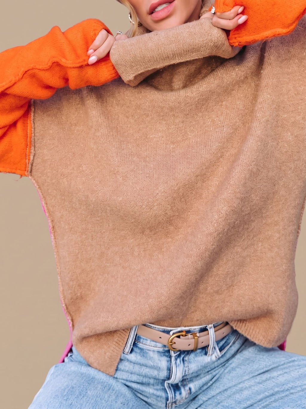 Detalle de la textura de punto del jersey color block en tonos camel, naranja y rosa