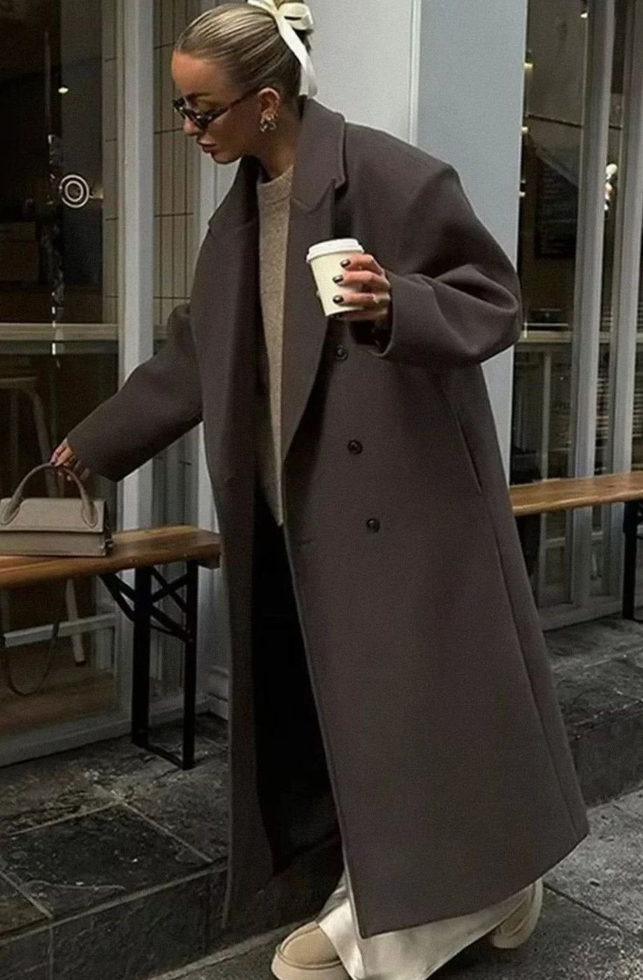 Mujer con abrigo largo oversize cruzado color marrón en look de invierno