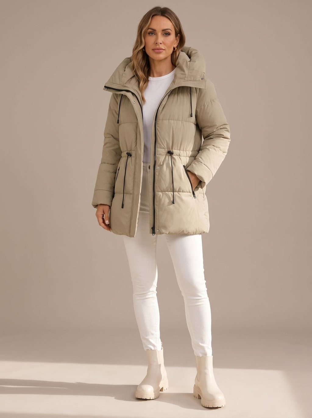 Mujer con chaqueta acolchada con capucha en color beige, vista frontal completa