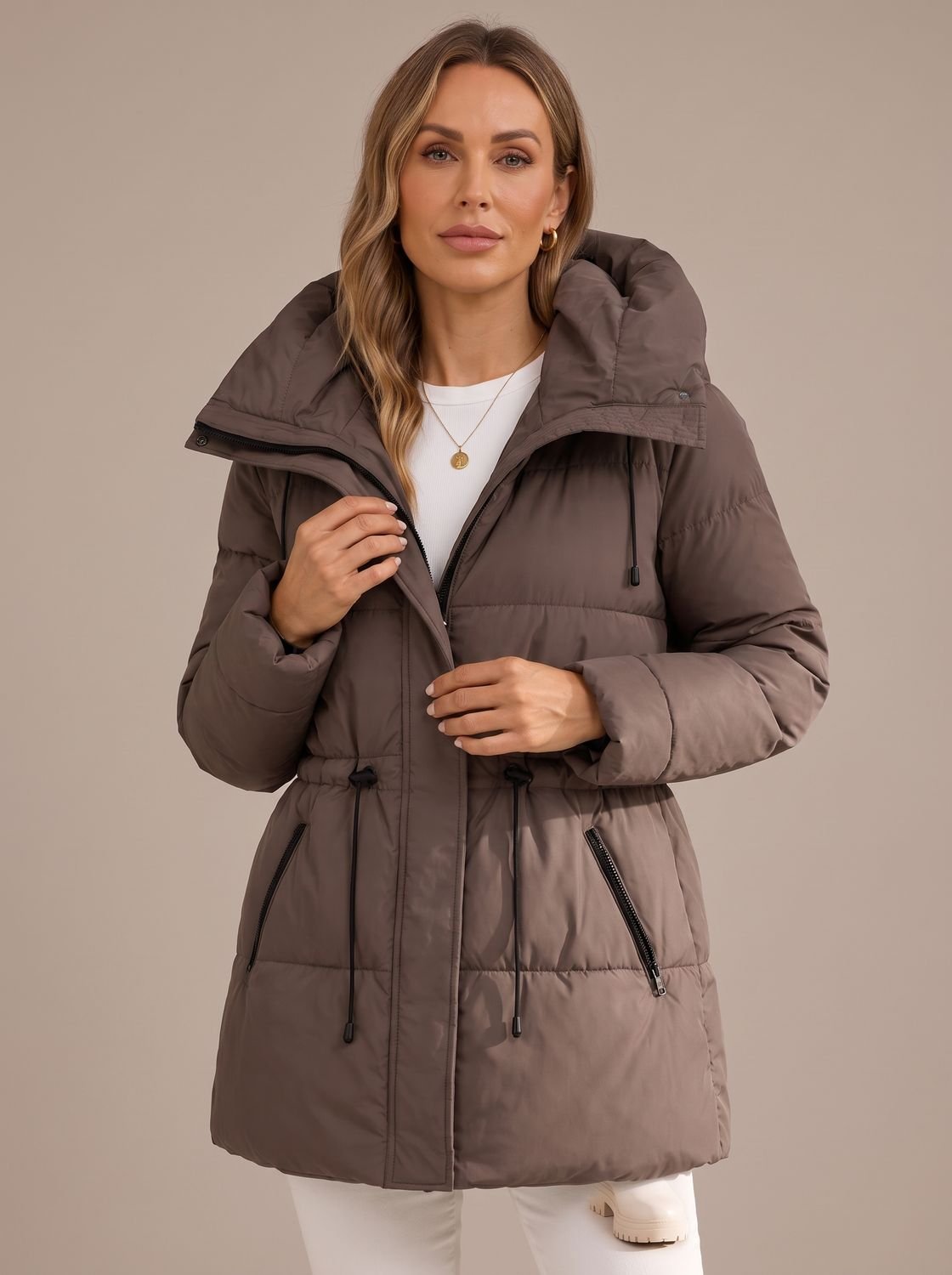 Vista lateral del corte largo de la chaqueta acolchada con capucha para mujer