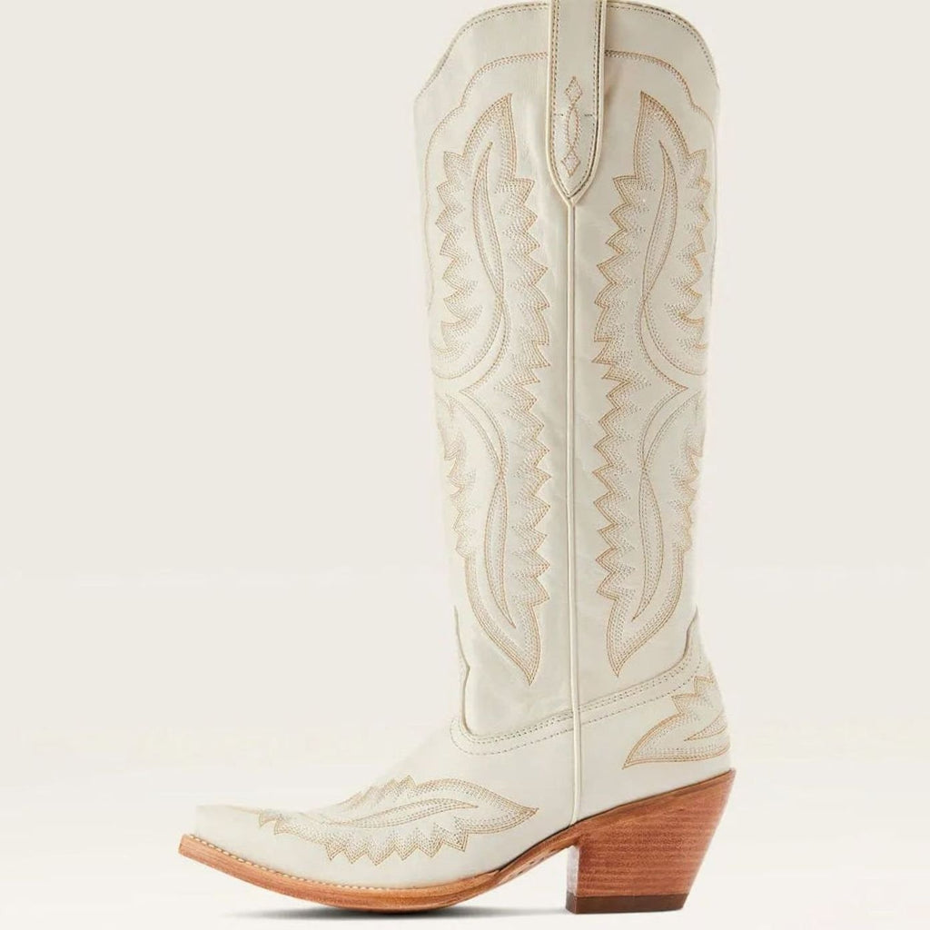 Botas altas bordadas de mujer sobre fondo neutro