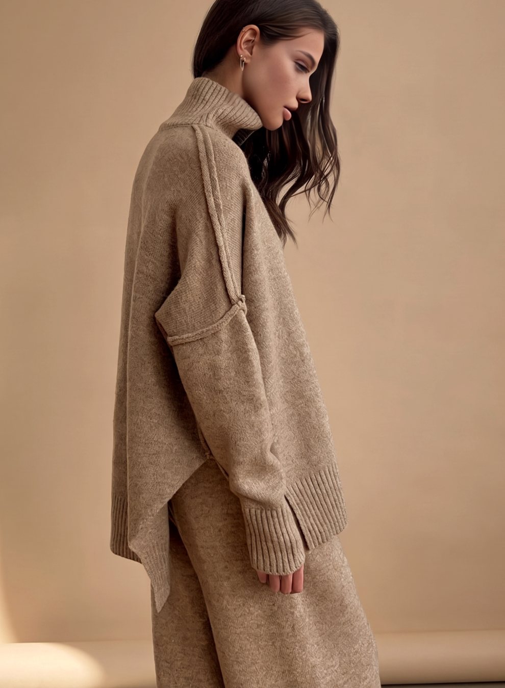 Mujer con conjunto de punto oversize cuello alto y pantalón ancho en color beige