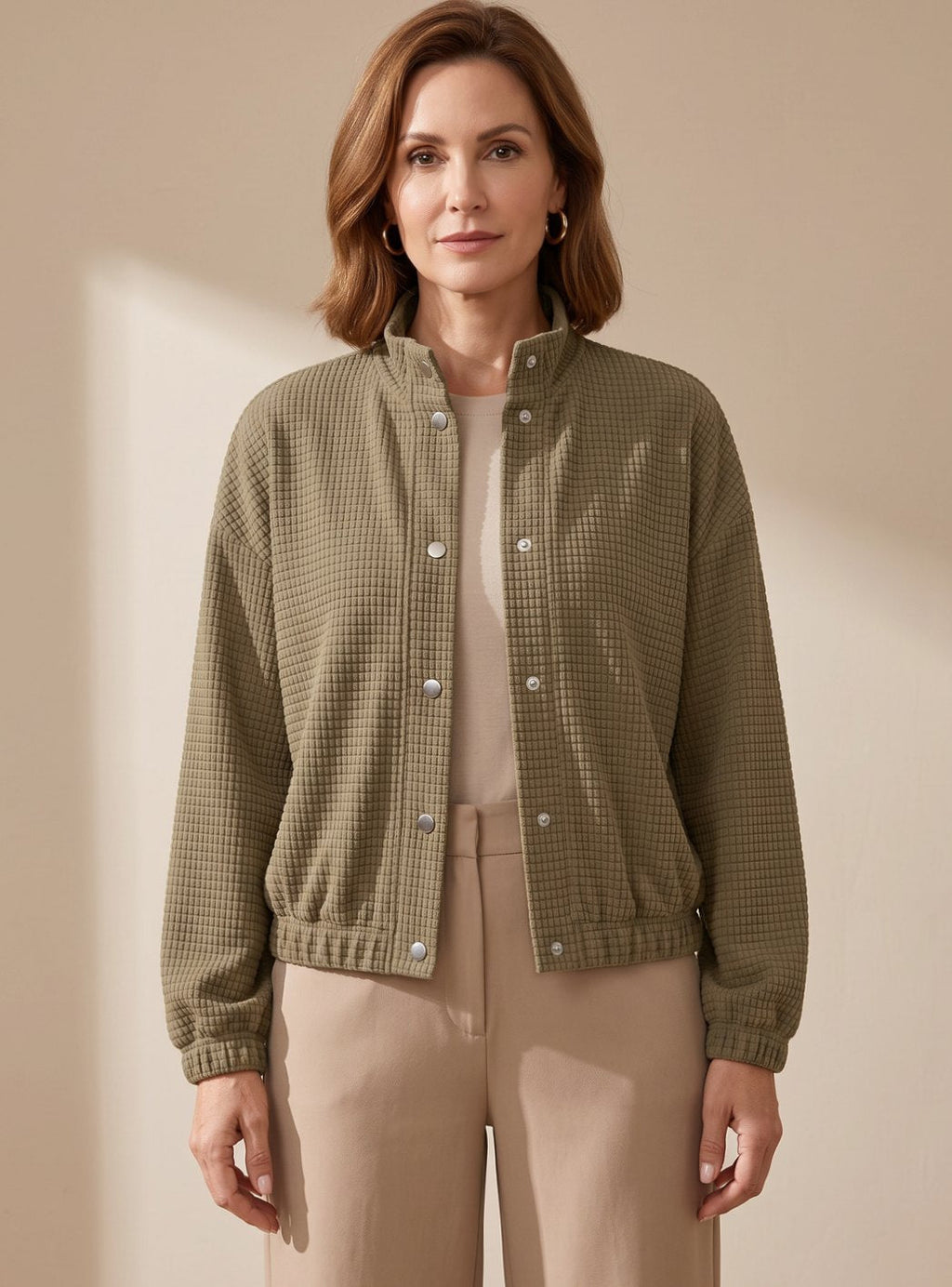 Mujer con chaqueta corta de punto waffle y cuello mao en look casual de entretiempo