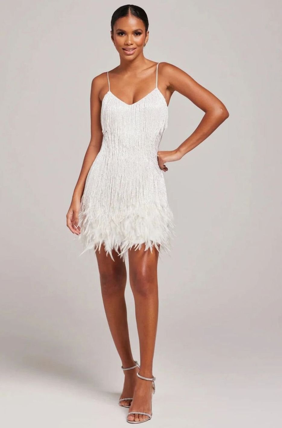 Vestido corto de mujer con flecos de pedrería y bajo de plumas para fiesta