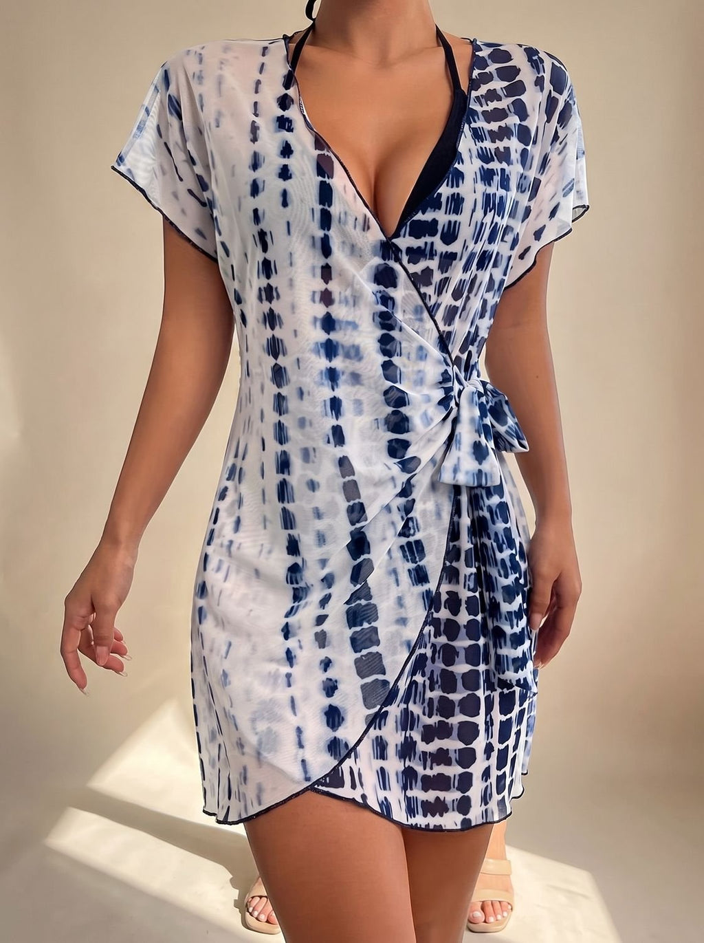 Pareo tie-dye de mujer combinado con bikini junto a la piscina