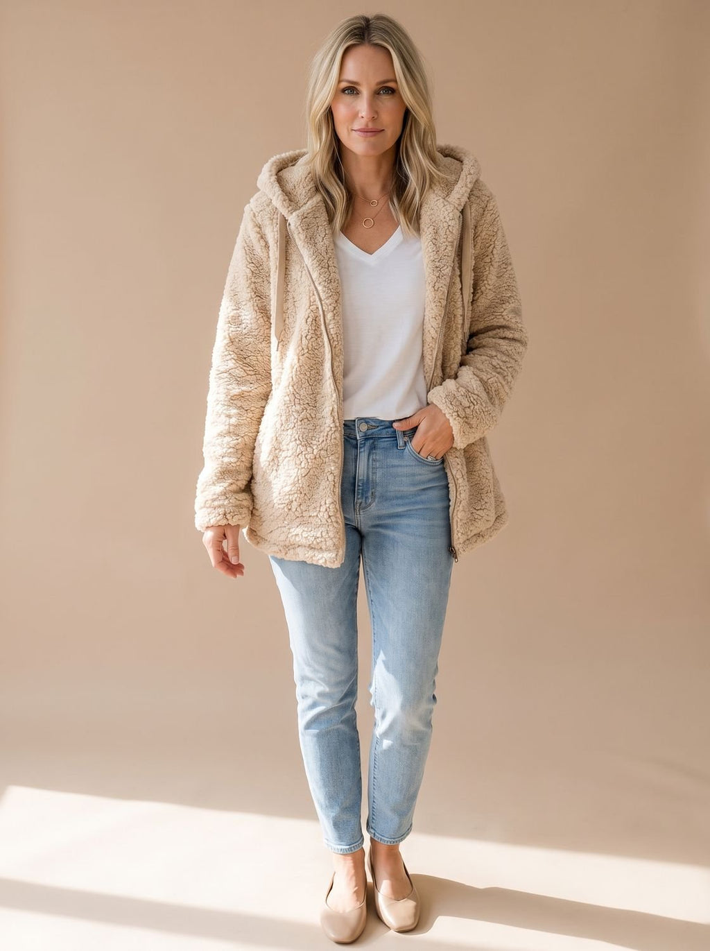 Mujer con abrigo oversize de borreguito con capucha en color liso