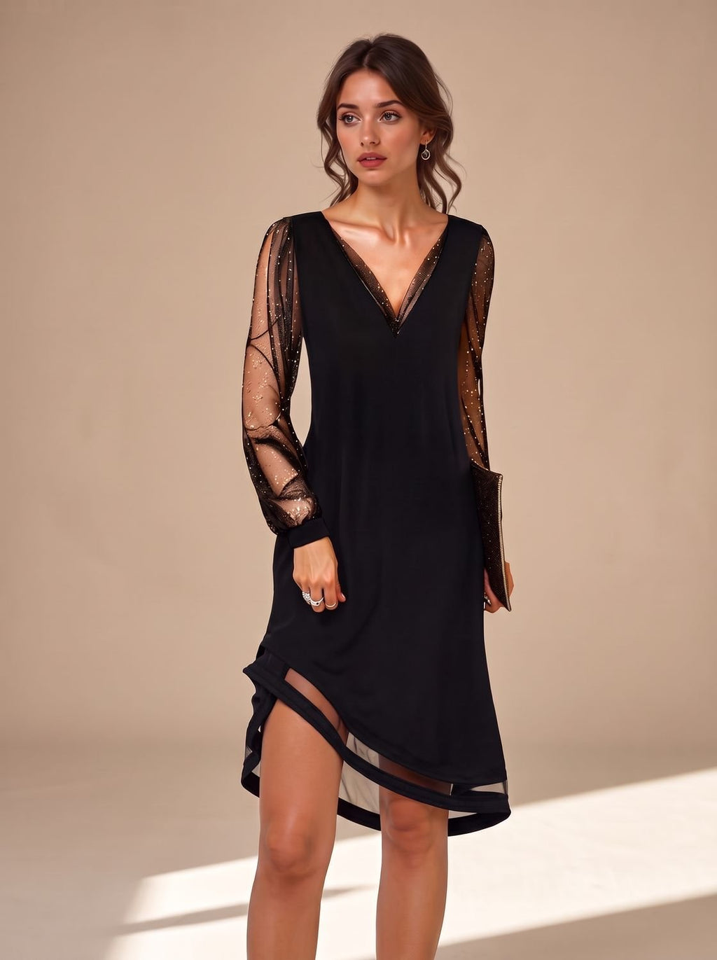 Detalle de las mangas de lentejuelas y el escote en V del vestido negro de fiesta