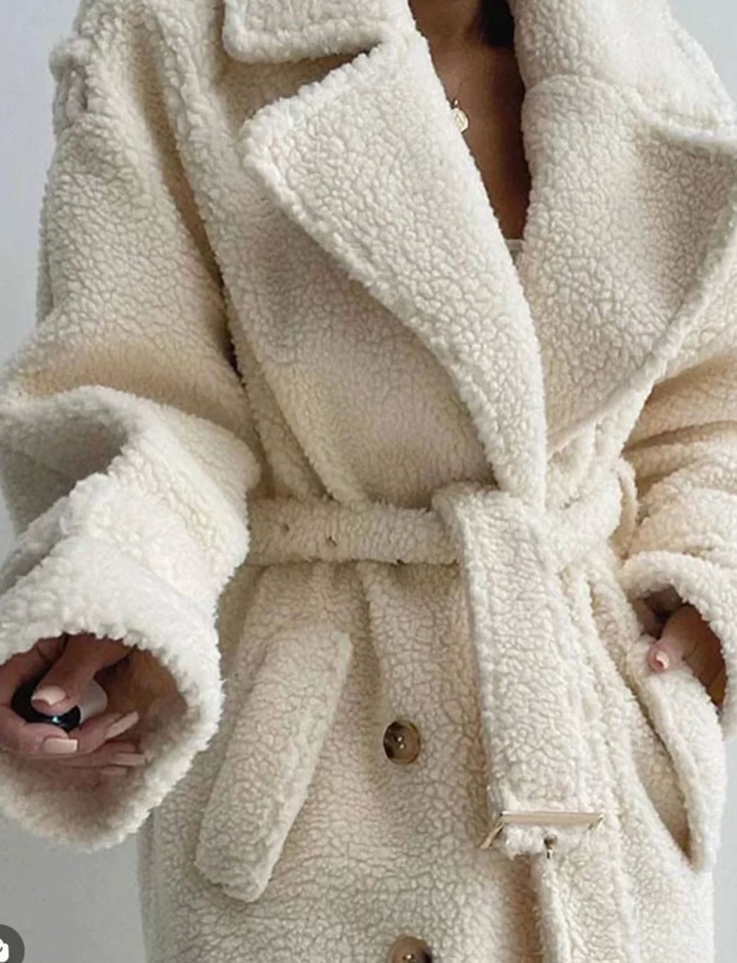 Cárdigan de punto con detalle de perlas colocado sobre un vestido