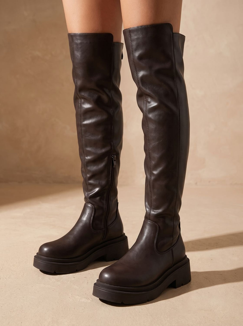 Modelo luciendo botas altas planas con vestido para salida de noche