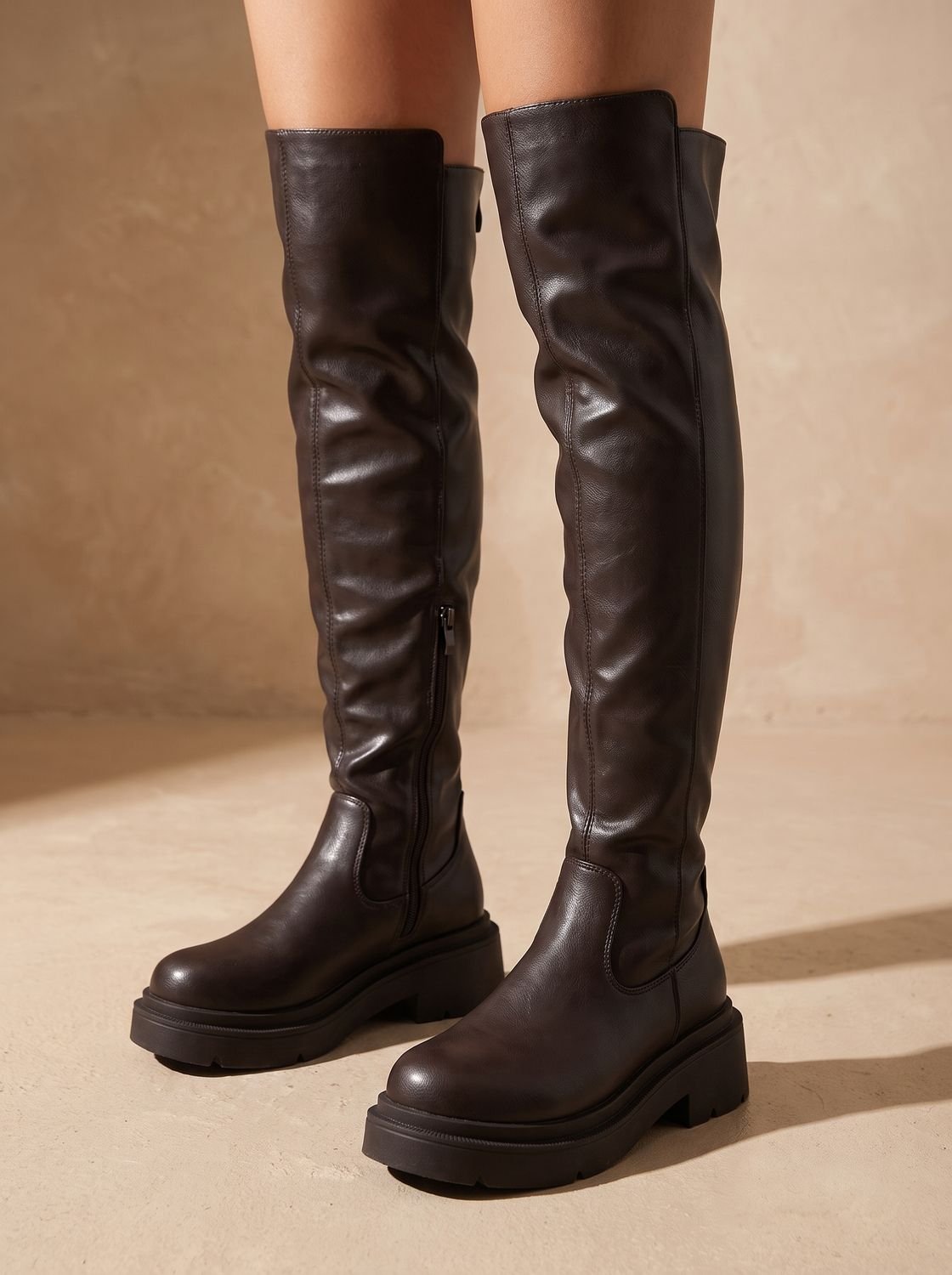 Modelo luciendo botas altas planas con vestido para salida de noche