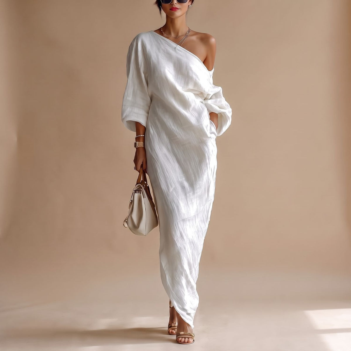Detalle del escote asimétrico y mangas 3/4 del vestido maxi blanco