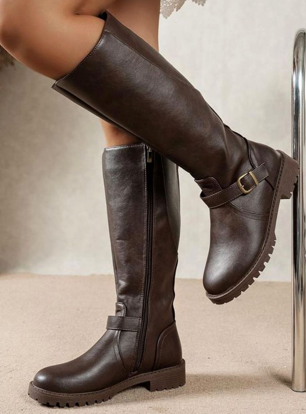 Detalle de la hebilla decorativa y la caña alta de las botas SOLVRAINE