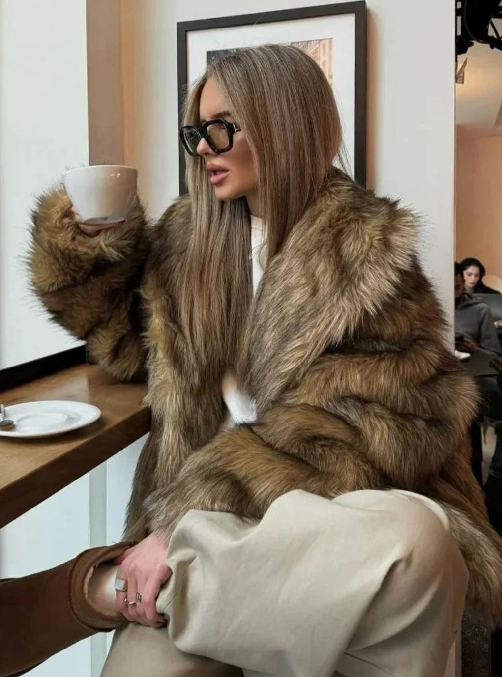 Detalle del pelo sintético mullido del abrigo marrón de invierno