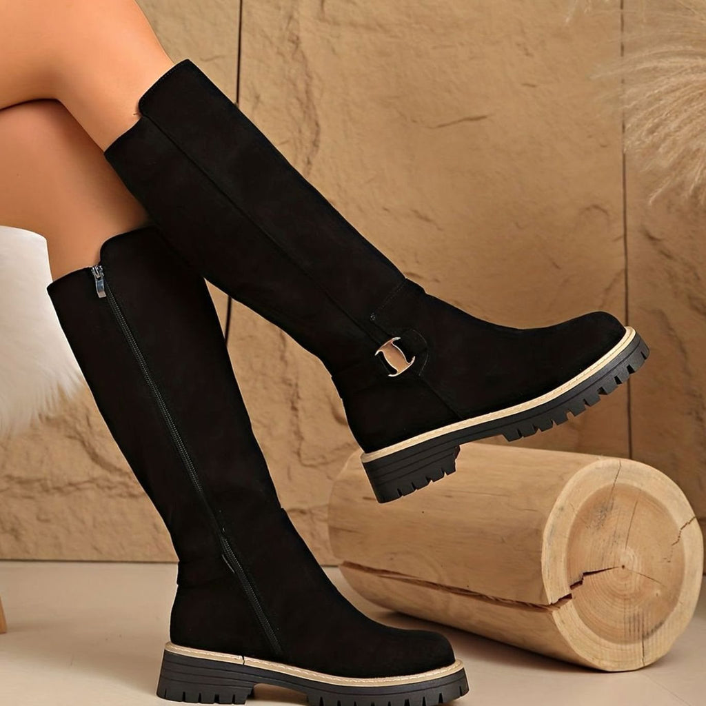 Botas altas de ante en color beige sobre fondo neutro