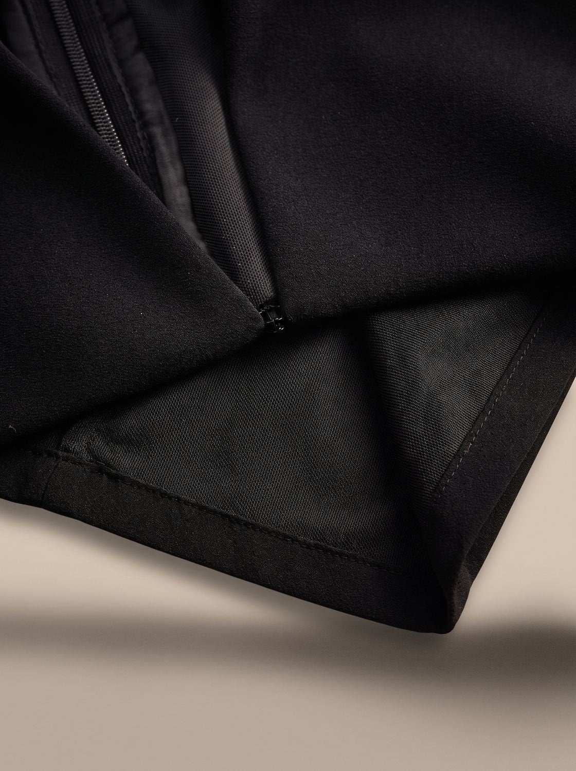Primer plano del vestido midi negro y su hebilla dorada cuadrada