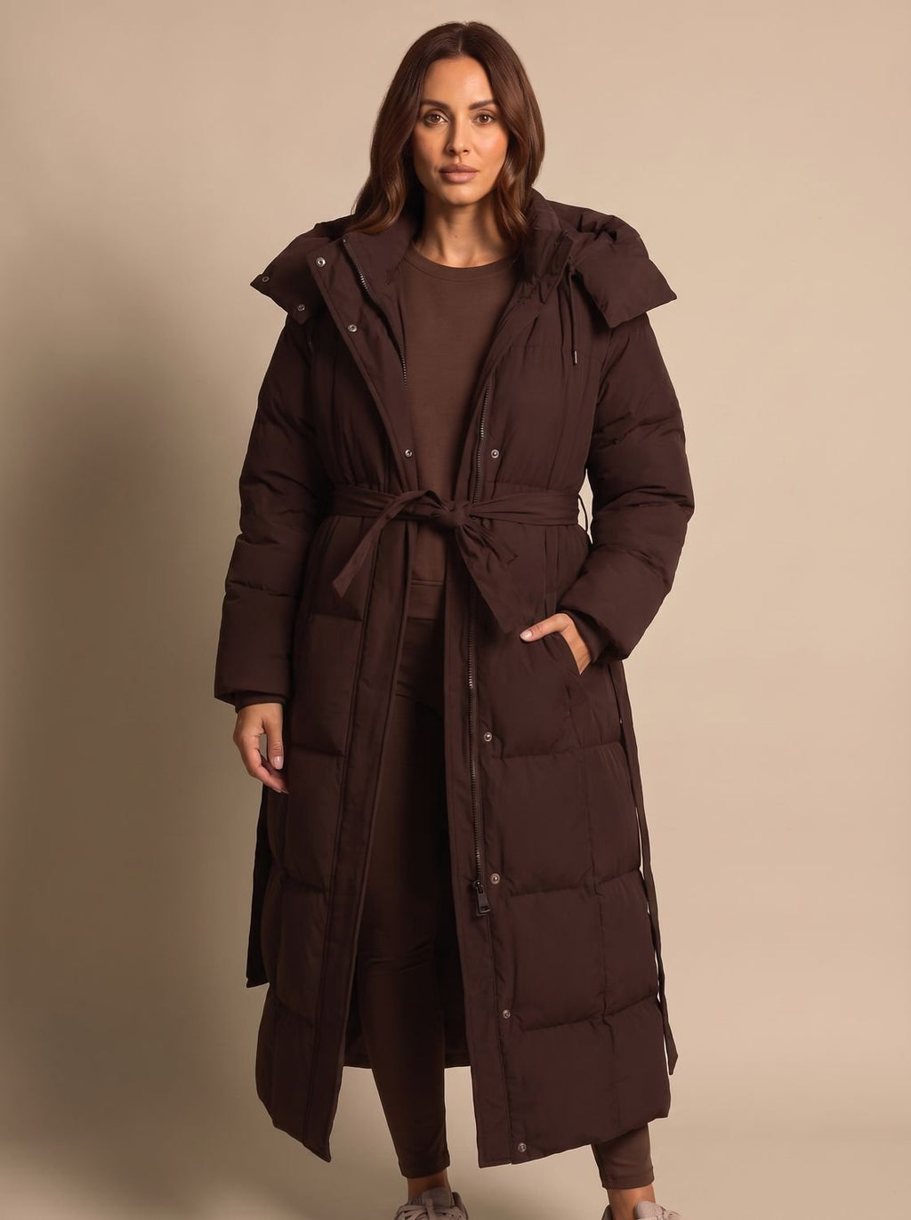 Mujer luciendo el abrigo largo con capucha en un look de invierno urbano