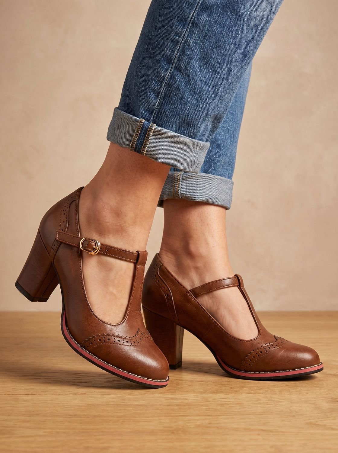 Detalle de la hebilla dorada y la tira T-bar del zapato brogue de tacón bloque